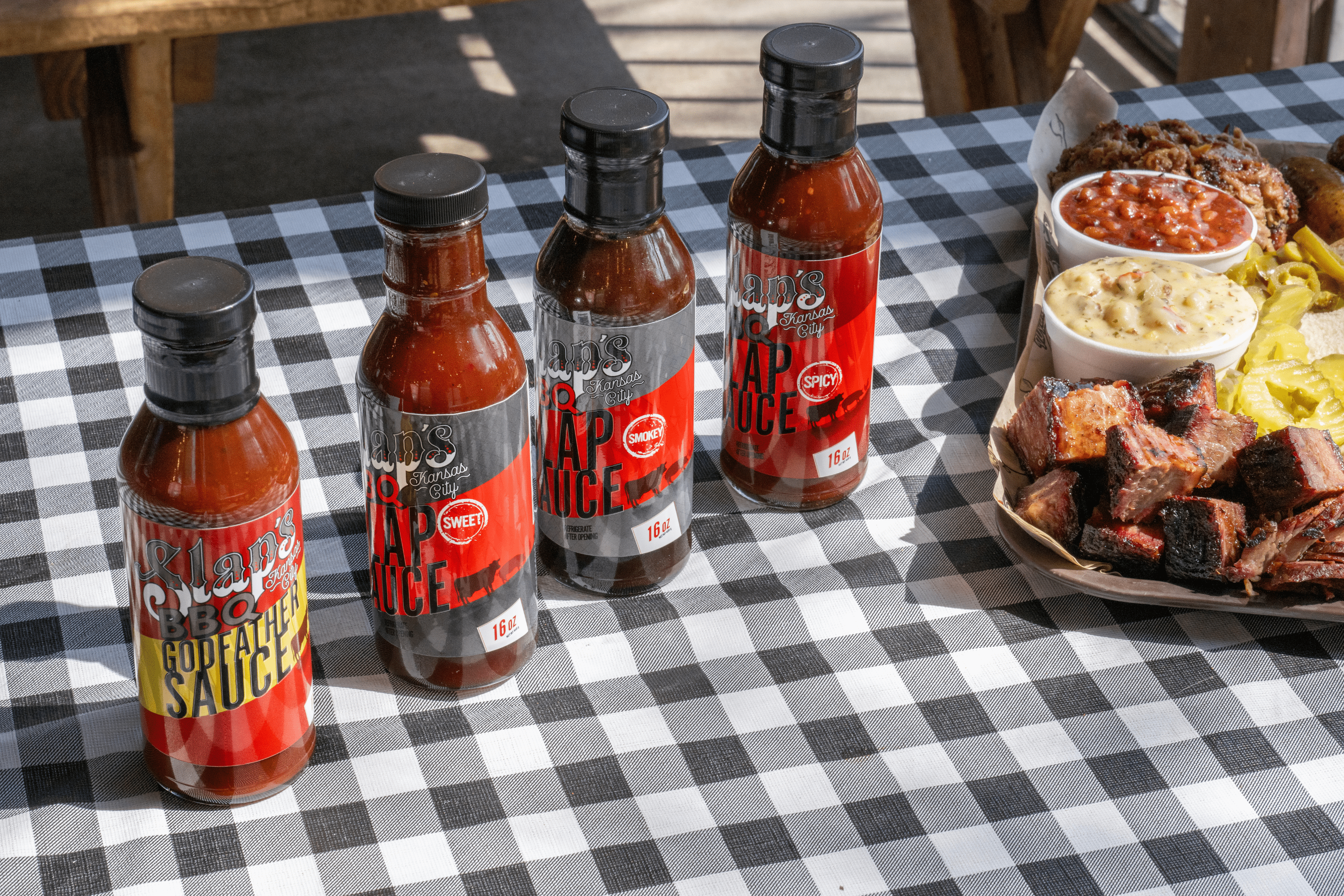 Bottles of Slap's BBQ sauces and rubs on a checkered clot
